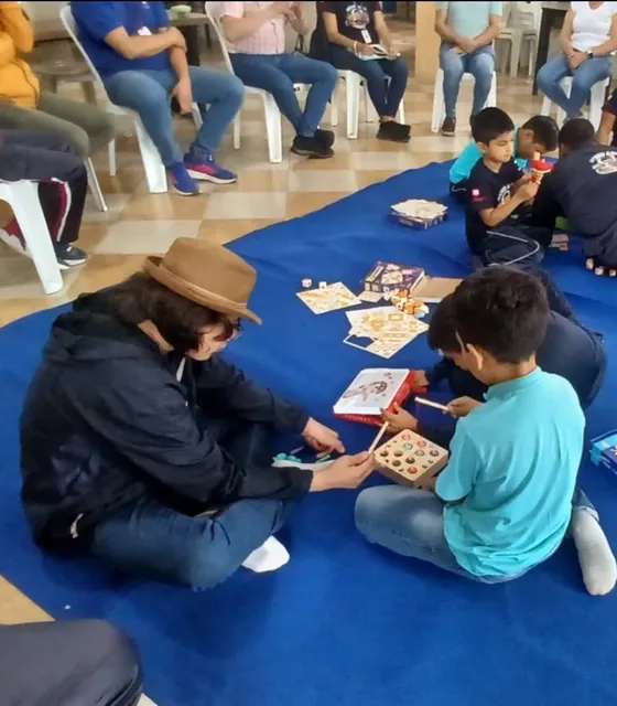 Niños participando en un taller en círculo junto a sus familias